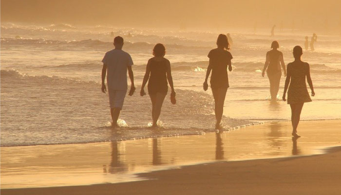 イメージ:夕陽の海辺で仲間と散歩